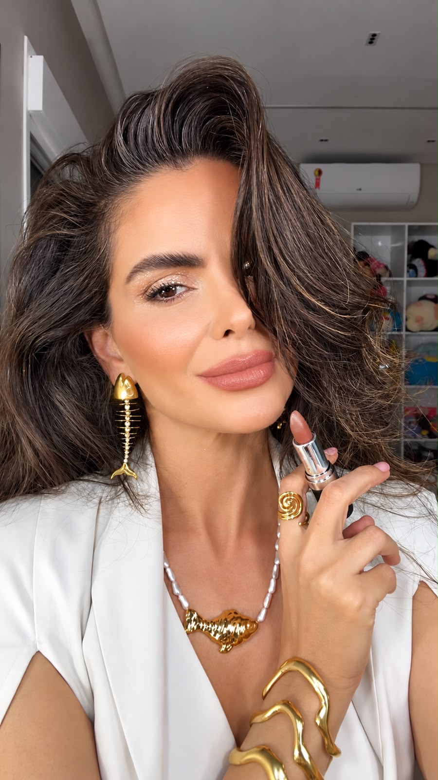 Mulher usando o batom Chic Glow e segurando o bastão